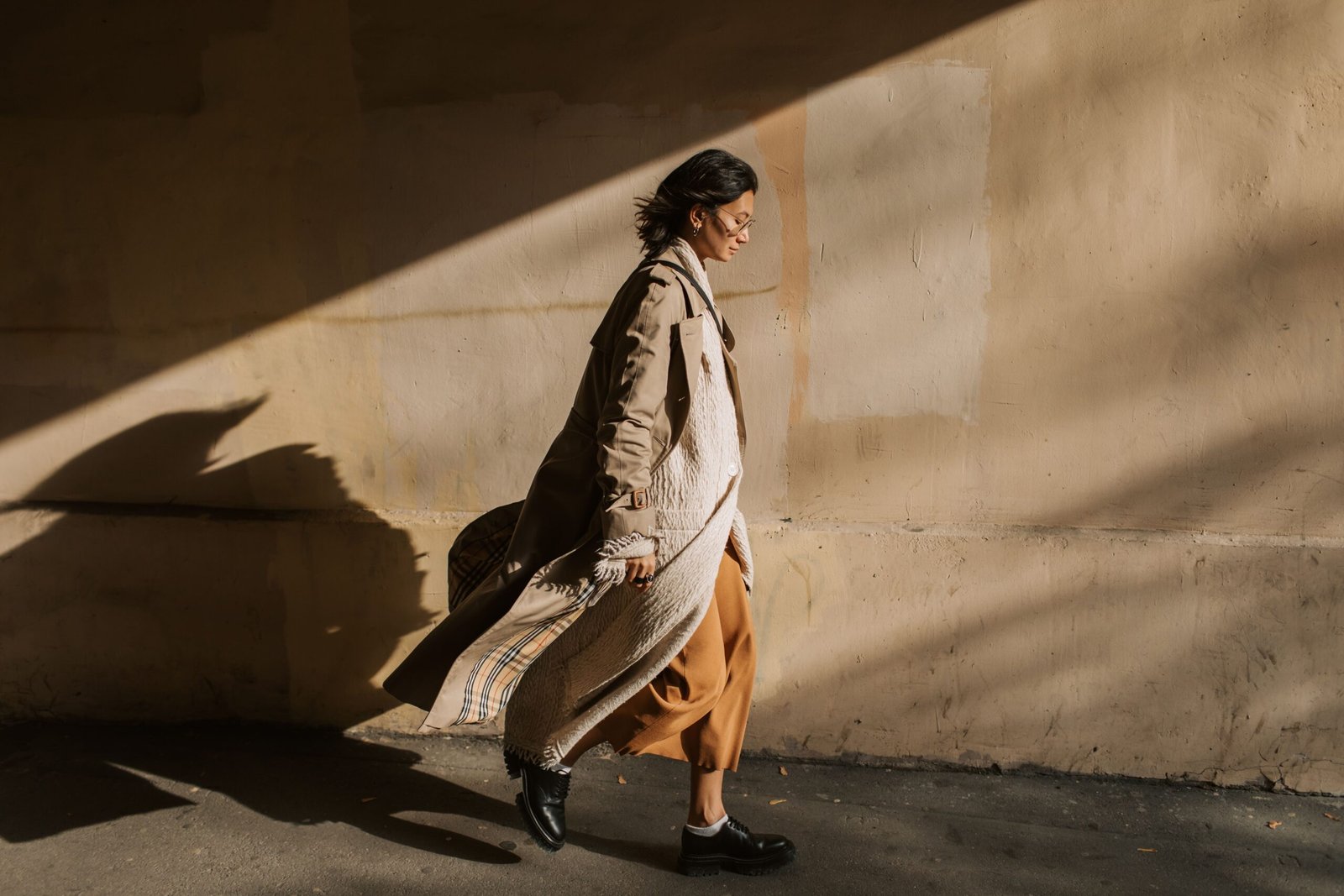 Stylish woman wearing a beige trench coat in autumn